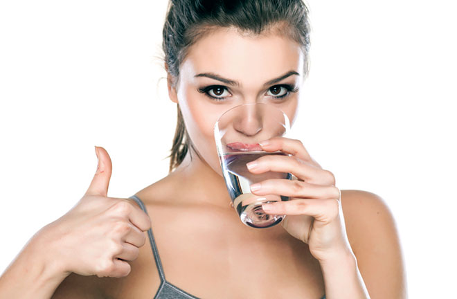 девушка пьет воду из стеклянного стакана