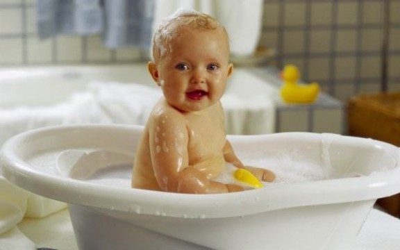 купание малыша в специальной ванночке