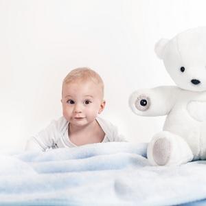 Малыш с белым плюшевым медведем