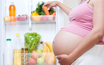 Беременная женщина шарит в холодильнике